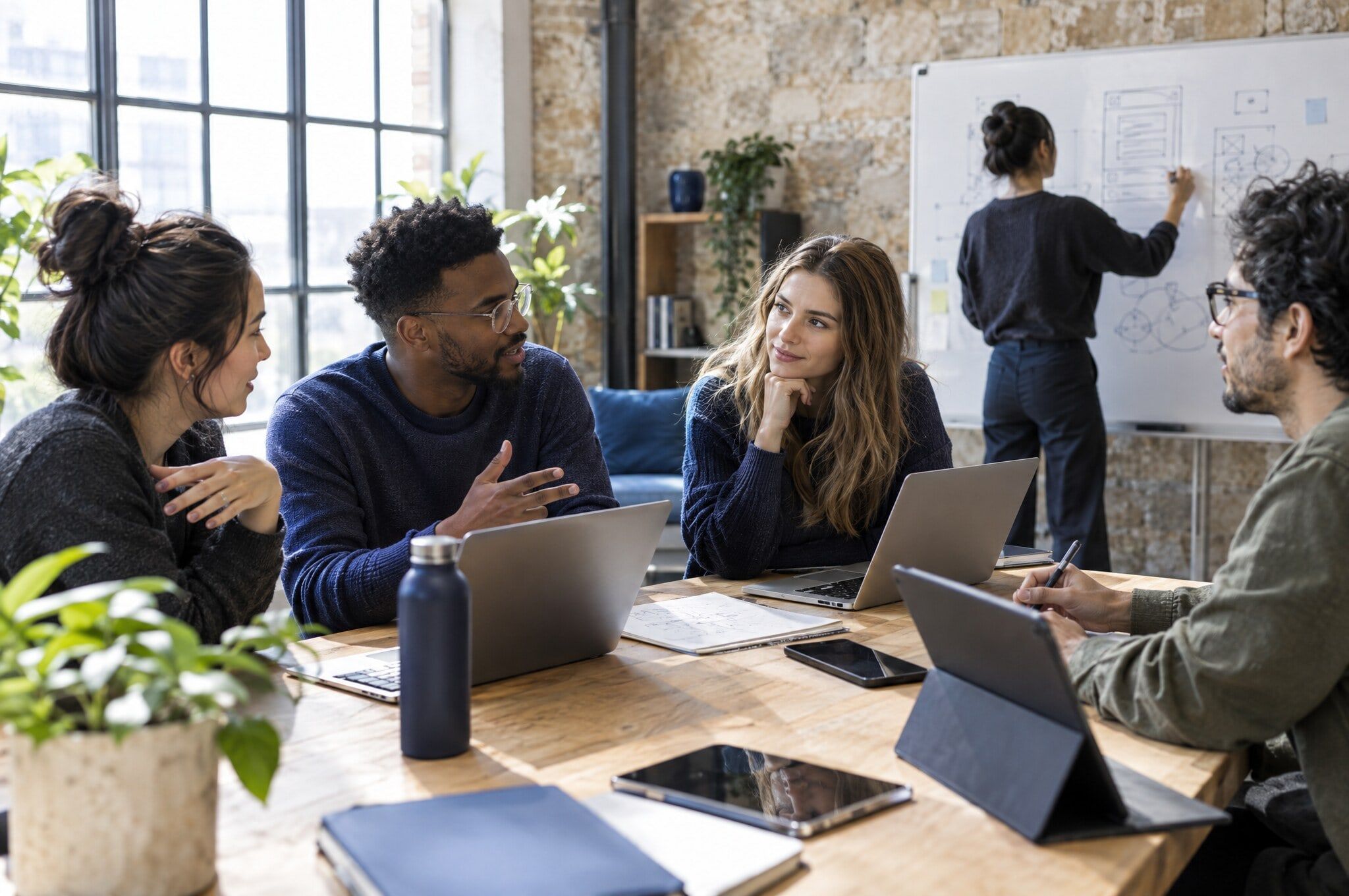 Engineers and designers collaborating around a table in a bright studio